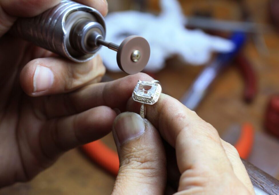 Jeweler polishing a diamond ring setting.